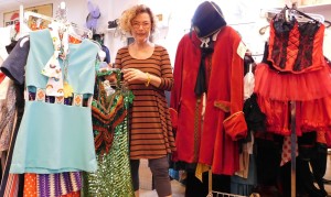 Nava Ottenberg holds a glittery Roaring 20s gown between displays of disco-era outfits, left, and a pirate's costume. 