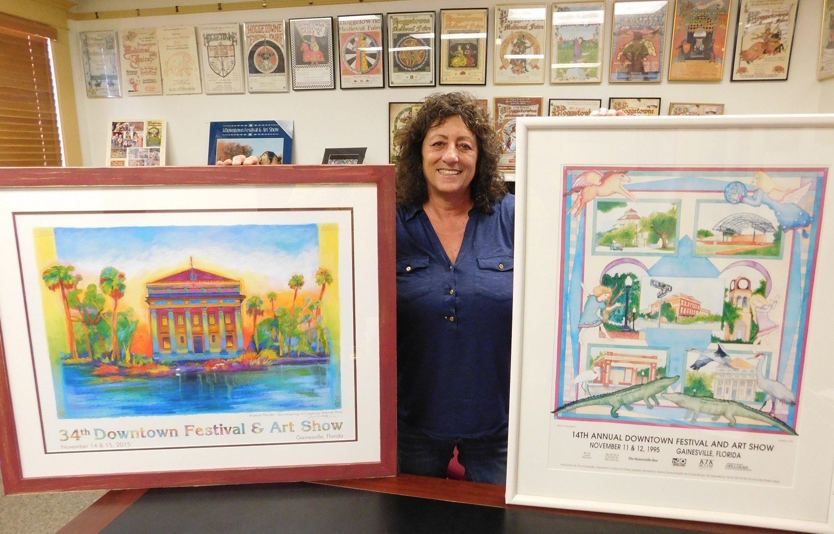 Linda Piper displays two Festival posters by Harriet Huss, one from this year and one from 1995. 