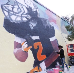 Reggie O'Neal, also known as L.E.O. works on his mural, a tribute to slain teenager Richard Hallman on the Looseys wall.