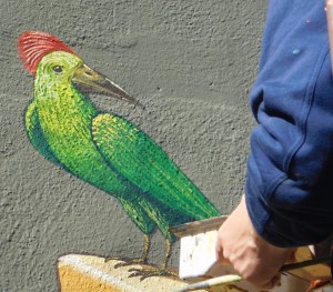 Aleksei Bordusov adds a tropical bird to the mural on the final day.