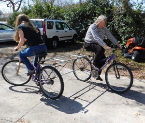 Flo Turcotte, right, and Lorraine Duerden try to figure out how to best operate the "push-me, pull-me" bike.