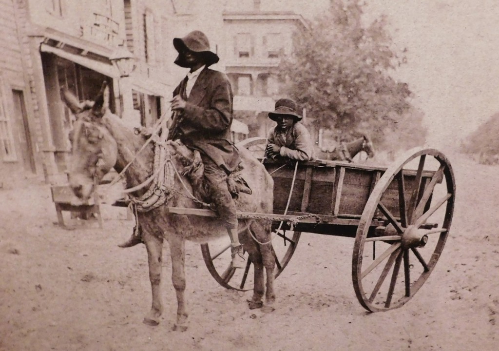 A black-and-white image from the 1880s or 90s shows two African Americans and their horse-drawn cart in downtown Gainesville. Photo from the Matheson Museum Collection)