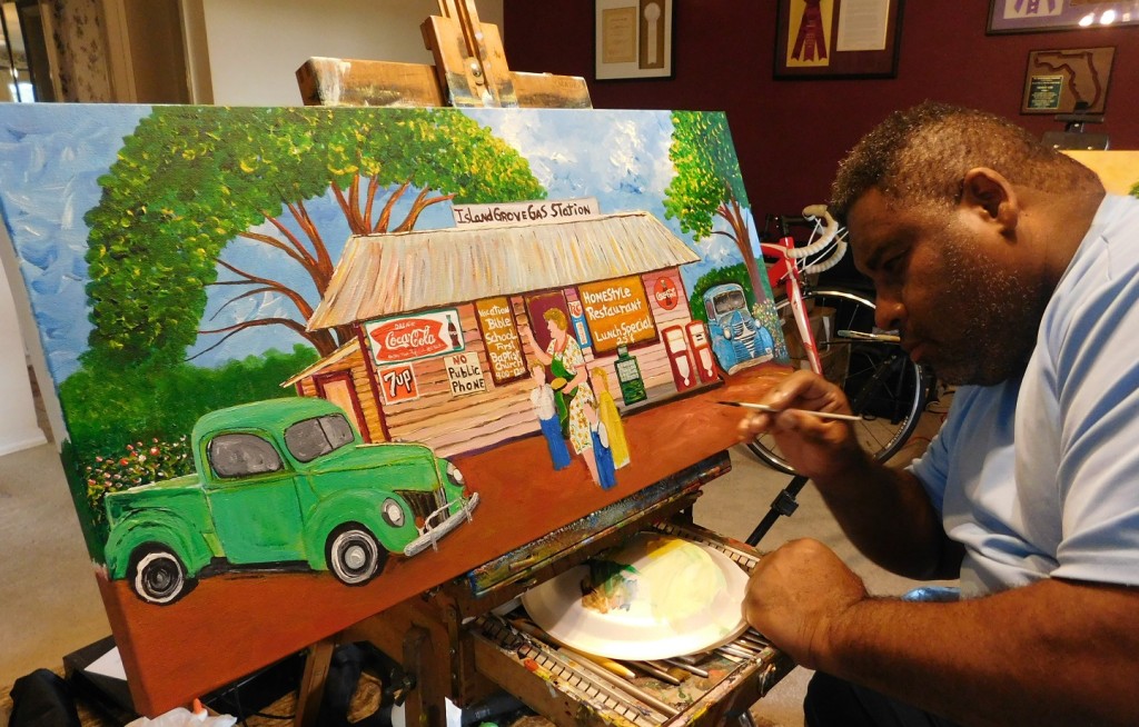 Ernest Lee works on his painting of the Island Grove gas station for Diane Adams. Photo by Gainesville Downtown)