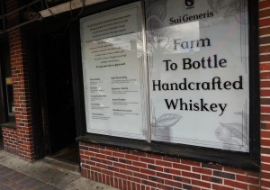 New signage on the front windows of the Fish Hawk Spirits Tasting Room promotes the companys Sui Generis whiskey brand.