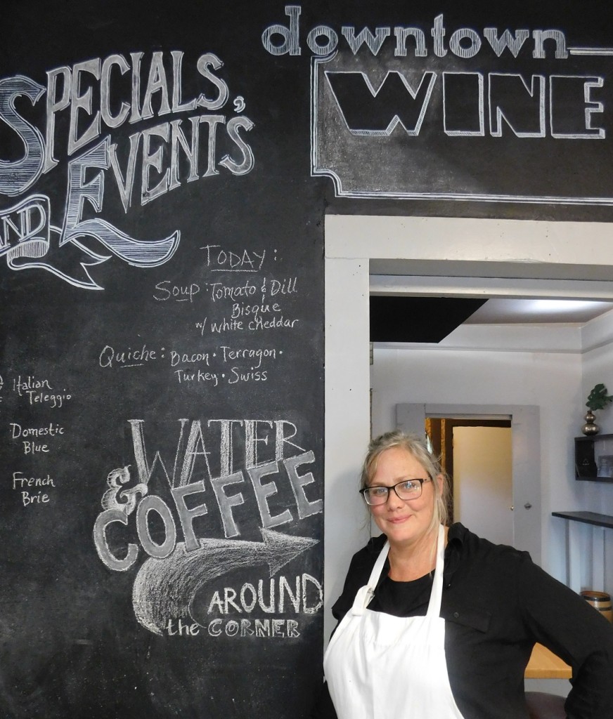 Downtown Wine Cheese owner Maude Wilson in front of her menu board that is updated daily. Photos by Gainesville Downtown)