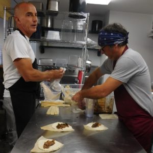 Anthony Campanaro, left, helps Nicholas Iannelli prep tamales. Photo by Gainesville Downtown)