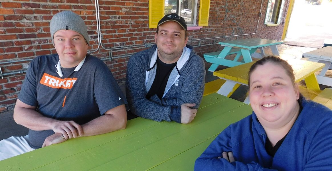 From left, Jacon Riesch, Tommy Newman and his wife, Shanti Riesch-Newman, are the co-owners of Piper Gis. Photo by Gainesville Downtown)