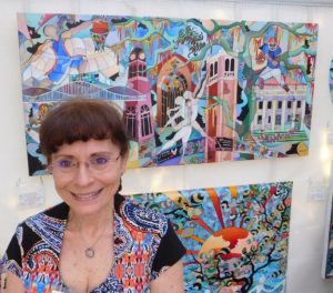 Miriam Novack and some of her acrylic paintings. Photo by Gainesville Downtown)